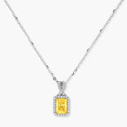 Yellow moissanite jewelry set with emerald-cut stones in sterling silver halo settings on white background.