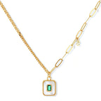 Gold-plated jewelry set with white enamel square pendants and emerald CZ stones on cream background.