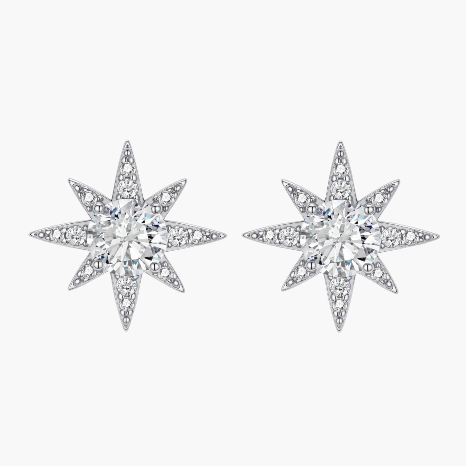 Sterling silver star-shaped stud earrings with brilliant moissanite center stones and pavé details on neutral background.