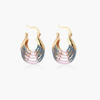 Gold hoop earrings with gradient blue-to-pink enamel in ribbed fan design on beige background