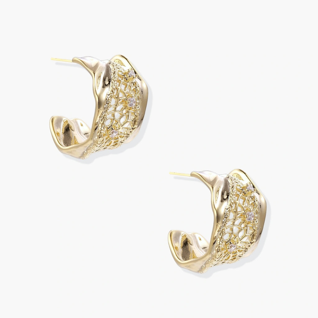 Gold-plated sculptural hoop earrings with geometric lattice centerband and sparkling zirconia on white background.