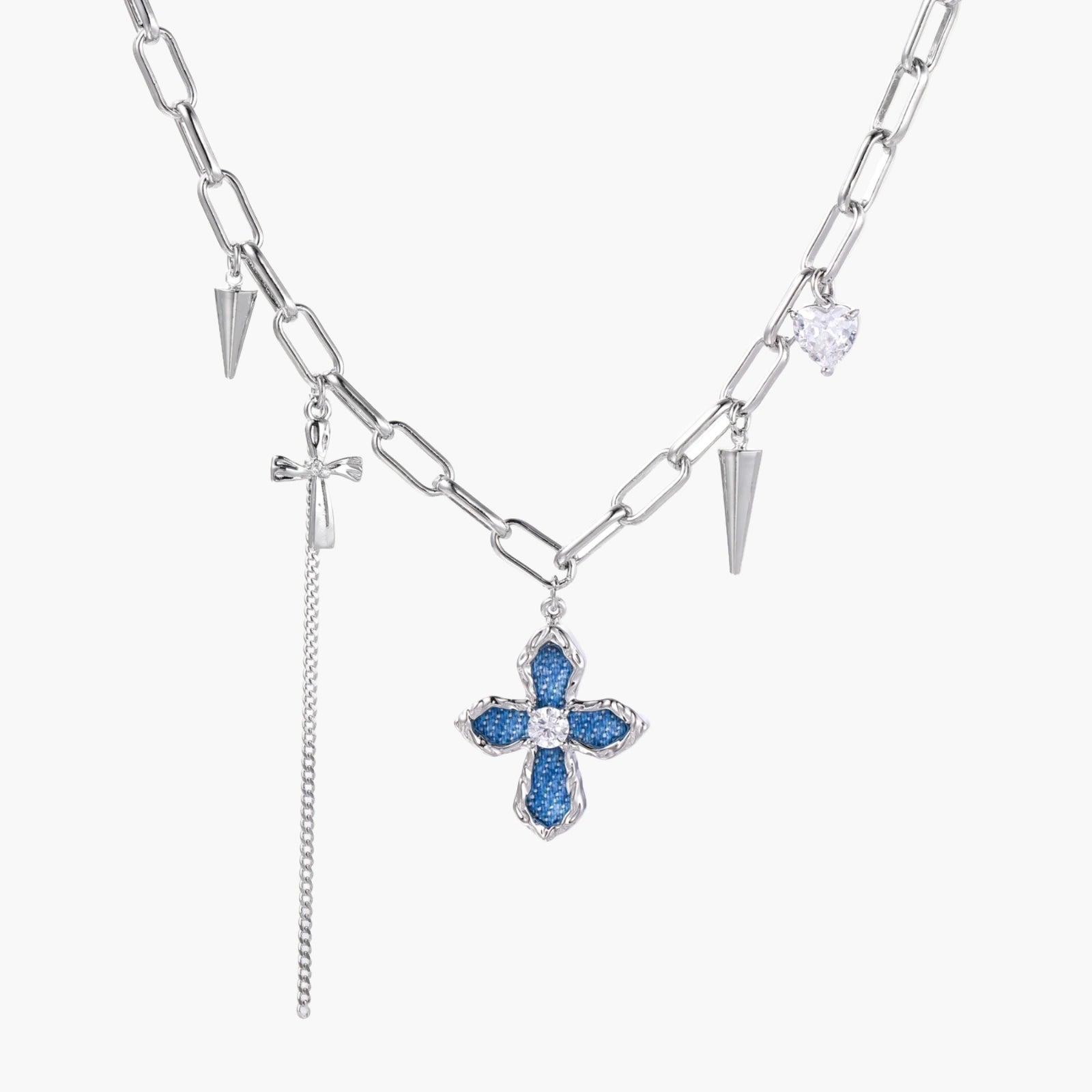 White gold plated chain necklace with blue textured cross pendant, spike charms, and mini cross detail on beige background