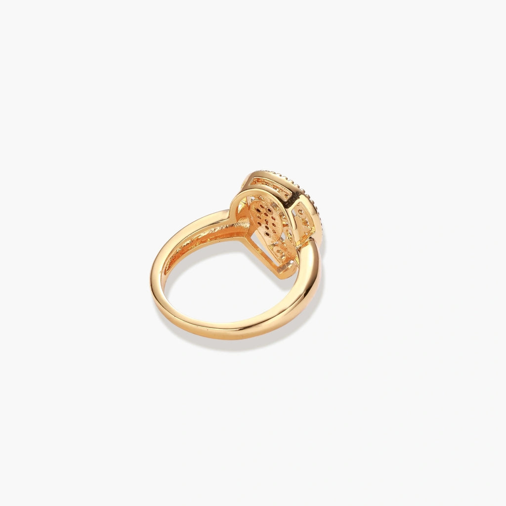 Teardrop-shaped gold-plated ring with turquoise enamel flowers and crystal pavé detail on cream background