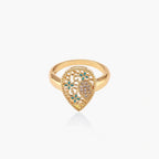 Teardrop-shaped gold-plated ring with turquoise enamel flowers and crystal pavé detail on cream background