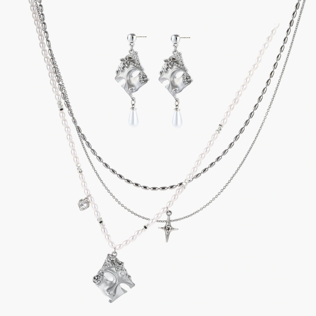 Ornate silver-toned masquerade mask jewelry set featuring rhinestone details and pearl drop earrings on white background.