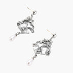 Ornate silver-toned masquerade mask jewelry set featuring rhinestone details and pearl drop earrings on white background.