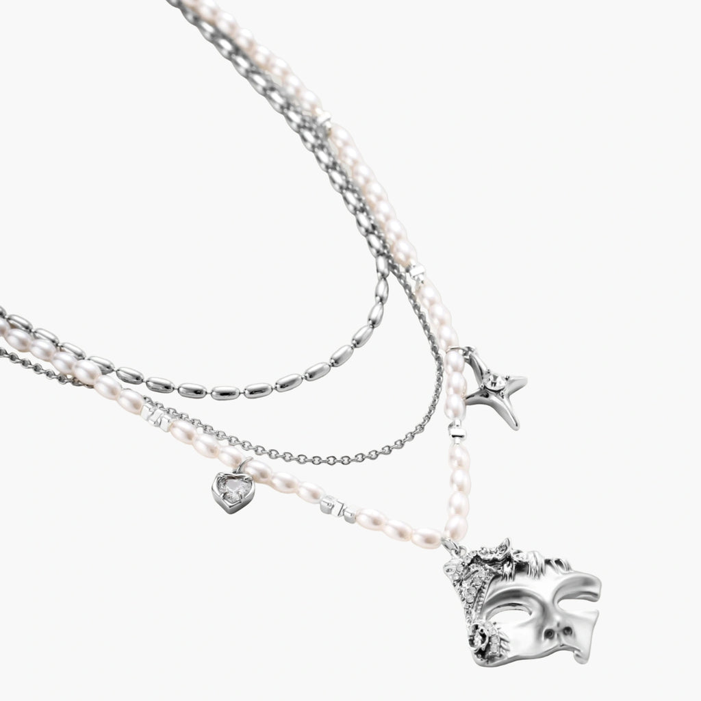 Ornate silver-toned masquerade mask jewelry set featuring rhinestone details and pearl drop earrings on white background.