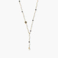 Y-shaped gold-plated necklace with white and gray freshwater pearls on cream background, showing adjustable drop design.